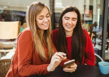 Two female friends looking at a smartphone